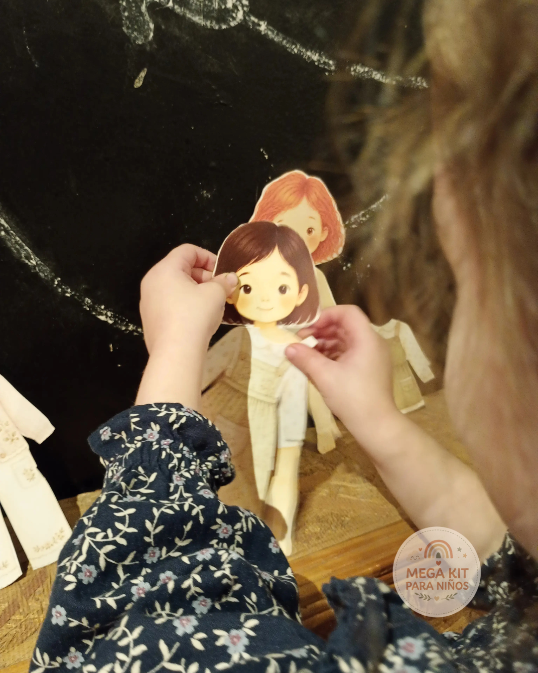 Niña jugando con muñecas de papel